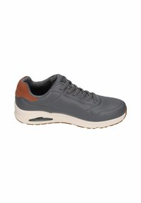 Zapatilla gris con parte superior sintética suave y acentos de gamuza marrón, que presenta una puntera redondeada, cordones en la parte delantera y una suela de goma con amortiguación de aire visible.