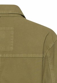 Bagsiden af en olivengrøn jakke med detaljeret syning og en krave mod en ensartet hvid baggrund.