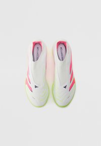 Fehér slip-on focicipők, élénk rózsaszín és zöld részletekkel, texturált felülettel és jellegzetes márkázással a talpbetéten.