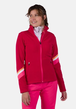 Fleecejacke in leuchtendem Pink, mit hohem Kragen, Vollzipper, zwei Seitentaschen und farblich abgesetzten Elementen in weißen, pinken und orangen Streifen.