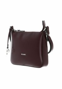 Borsa a mano in pelle bordeaux con una finitura liscia, chiusura con zip, tracolla regolabile e hardware in tono argento. Presenta un piccolo logo sulla parte anteriore.