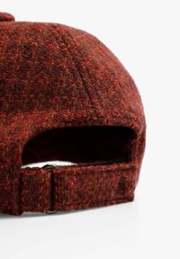 Gorra de lana en tonos mezclados de rojo y marrón, con visera plana y correa ajustable en la parte trasera con herrajes metálicos.