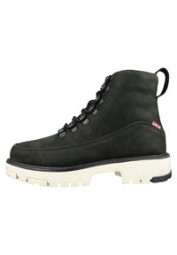 Groene suède enkellaarzen met een gestructureerde afwerking, witte rubberen zool, zwarte veters en een klein rood logo aan de zijkant.