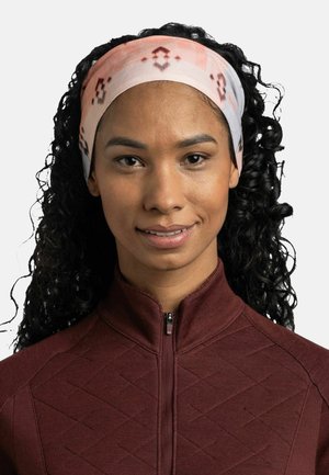 Diadema con un tejido suave y ligero en colores pastel, con un patrón de formas geométricas. Se lleva con una chaqueta de cremallera color burdeos con textura.