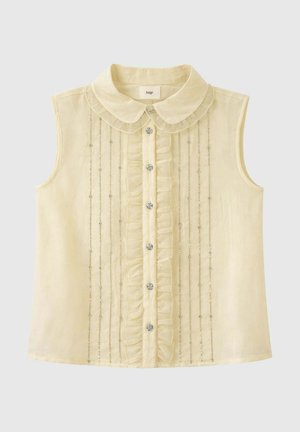 Blouse crème sans manches avec col rond, volants verticaux, boutons effet cristal et ornements de perles argentées sur le devant.