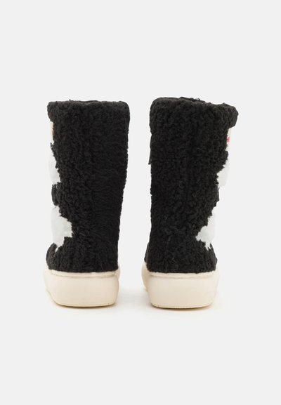 Zapatillas altas negras hechas de un material suave y texturizado, con patrones de nubes blancas y una suela de goma color crema.
