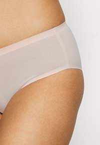Ljust rosa genomskinliga hipsterunderbyxor med en mjuk elastisk midjeband, som har minimal sömnad och en mjuk, matt finish.