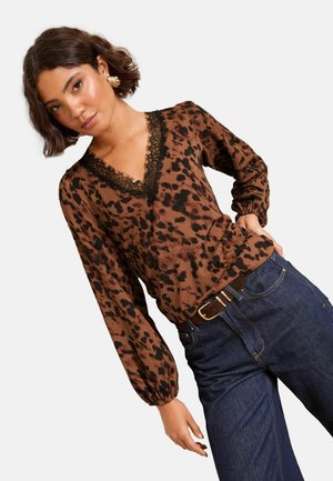 Brown leopard print top with a v-neck and black lace trim, featuring long puff sleeves and a textured fabric, paired with denim jeans.