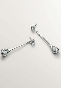 Pendientes de plata de ley con diseño en forma de lágrima y piedras preciosas transparentes, un par de studs y un par colgantes, textura suave.