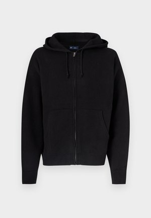 Mustast pehmest puuvillasegusest kangast lukuga kapuutsiga pusa. Omadused: nööriga kapuuts, ees taskud ning soonikkoes mansetid ja ääred.