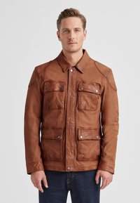 Braune Lederjacke mit vier Fronttaschen, Druckknopfverschluss und klassischem Kragen. Glatte Textur, tailliertes Design und Schulterakzente.