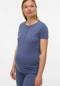 Haut de maternité court et à manches courtes, bleu clair, fabriqué en tissu doux avec un col rond et des détails de boutons sur le devant, ajusté à la taille.