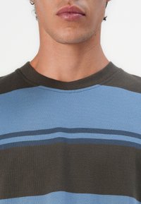 Short-sleeve T-shirt featuring horizontal stripes in light blue, dark blue, and olive green. Soft fabric with a round neckline.