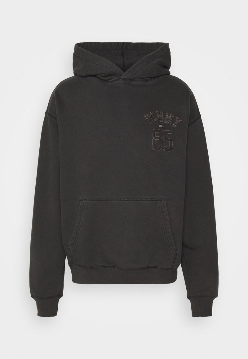 Sweat à capuche noir avec poche frontale et texte "TOMMY 85" imprimé sur la partie supérieure gauche de la poitrine.