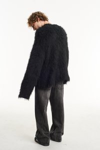 Black fluffy sweater with a loose fit and wide sleeves, paired with dark gray straight-leg jeans, creating a casual ensemble.