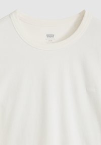 Λευκό βαμβακερό μπλουζάκι με στρογγυλή λαιμόκοψη, άνετη εφαρμογή και μικρό λογότυπο της μάρκας στο στήθος. Μαλακή υφή και λεία τελείωμα υφάσματος.