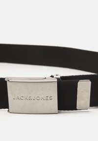 Sort elastisk bælte med en sølvfarvet metalspænde med indgraveret tekst "JACK & JONES" og et rektangulært endeled. Holdbart og sikkert design.