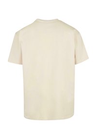 Koszulka bawełniana w kolorze kremowym, z krótkim rękawem, okrągłym dekoltem i gładkim tyłem. Miła w dotyku, luźny krój. Bez wzorów ani akcentów.