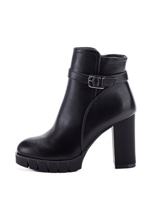 Schwarze Leder-Stiefelette mit Blockabsatz, dickem Profilsohle und dekorativem Riemen um den Knöchel.