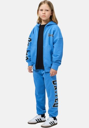 Bright blue hoodie and sweatpants set, with "UNITED" in bold black lettering on the arms and pants. Features a relaxed fit and soft texture.