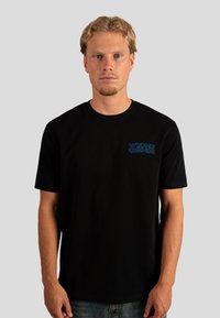 Czarny bawełniany t-shirt z krótkim rękawem, z niebieskim napisem "WRONG FRIENDS" po lewej stronie klatki piersiowej. Regularny krój i gładka faktura.