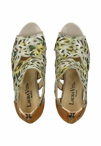 Sandalias de punta abierta con una parte superior tejida multicolor que presenta diseños recortados. Detalles en piel color beige en el talón, con cierre de cremallera.