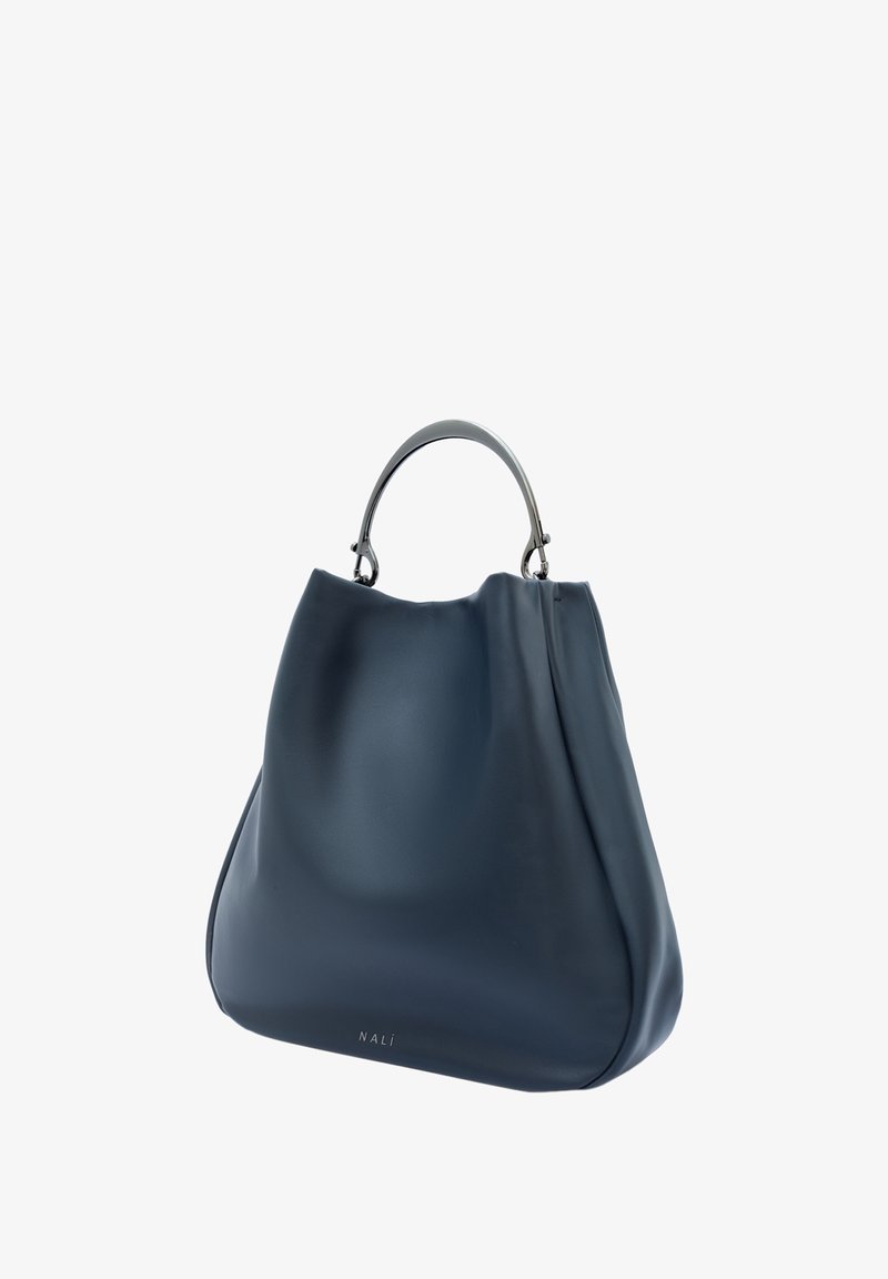 Bolso de mano de cuero azul con forma curva, herrajes en tono plateado y un logotipo prominente en la parte inferior. Textura suave con detalles mínimos.