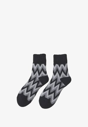 Schwarz-grau gezackte Socken mit Rippbündchen, aus einem weichen Material; knöchellang mit strukturierter Oberfläche.