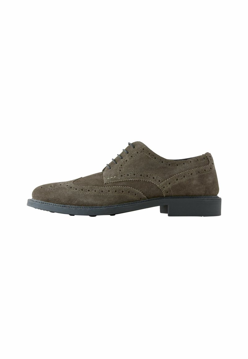 Semišové dress shoes v tmavošedej farbe s brogue detailmi, zaoblenou špičkou a šnurovaním. Obsahuje kontrastnú čiernu gumovú podrážku.