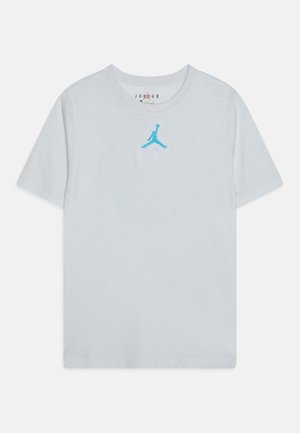 Camiseta de manga corta de color gris claro con logo Jumpman azul centrado en el pecho y cuello redondo.