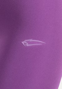 Paarse sportstof met een gladde textuur en een subtiel logodesign in een lichtere tint paars.