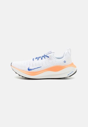 Baskets de course Nike avec une tige en maille blanche, des accents bleus, une semelle intermédiaire orange et une semelle extérieure noire texturée. Design léger et respirant.