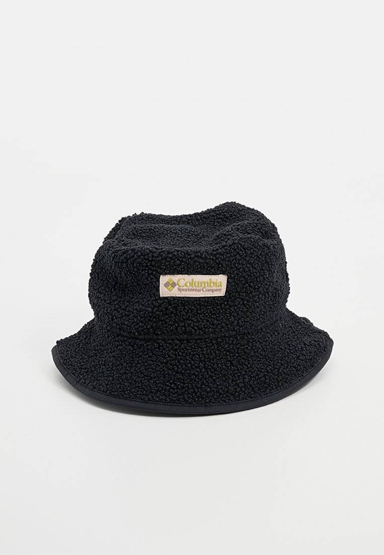 Chapeau seau noir en tissu texturé avec une surface douce et duveteuse. Présente un bord contrastant et une étiquette sur le côté.