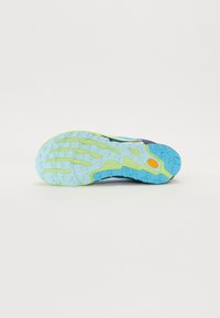 Semelle de chaussure de trail running présentant un design principalement bleu et vert, avec une surface texturée et des crampons pour l'adhérence.
