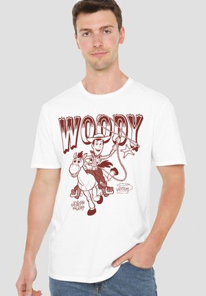 Man wearing white t-shirt with maroon Woody and Bullseye cartoon from Toy Story, featuring lasso and sheriff badge graphics.