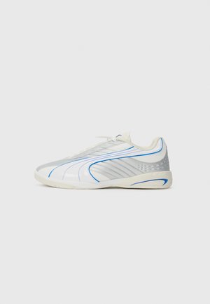 Tenis com um cano branco e brilhante, detalhes em azul e painéis laterais texturizados em prata. Apresenta um bico arredondado e fecho por atacador.