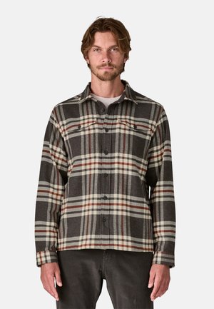 Camicia di flanella a quadri in grigio scuro, crema e bordeaux. Presenta una chiusura con bottoni frontale, colletto a punta e maniche lunghe con dettagli ai polsini.