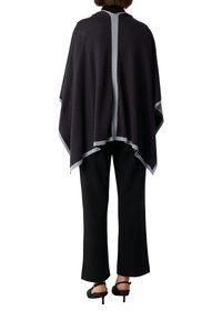 Czarny poncho wykonane z miękkiego materiału, z kontrastowym jasnoszarym wykończeniem wzdłuż krawędzi oraz rozcięciem na środku pleców.