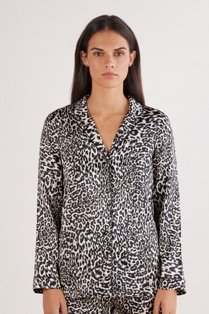 Leopard print pajama set in soft fabric, featuring a collared shirt with long sleeves and a button closure, highlighting contrasting black and beige colors.