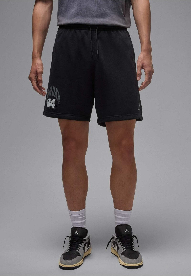 Zwarte katoenen korte broek met een elastische tailleband, voorzien van een witte "Jordan 84"-grafiek. Draag met zwarte en grijze sneakers en witte crew-sokken.