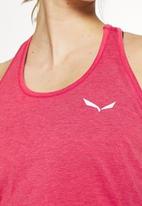 Canotta rossa realizzata in tessuto morbido e leggero, con scollo rotondo e un piccolo logo bianco sull'area del petto.