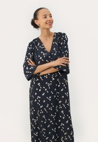 Marineblaues Kleid mit V-Ausschnitt und weiten Ärmeln bis zum Ellbogen; verfügt über ein dezentes, bedrucktes Muster in metallischen Tönen und eine glatte Stoffstruktur.