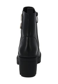 Czarne skórzane botki za kostkę z grubym obcasem, bocznym zamkiem błyskawicznym i podwójnymi złotymi klamrami, pokazane z tyłu.