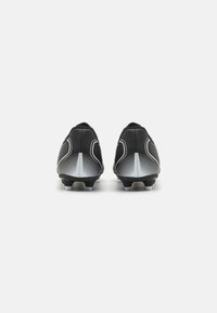 Musta jalkapallokengät, joissa on tyylikäs muotoilu, teksturoitu päällinen ja kontrastiset harmaat raidat. Pohjassa on useita nappuloita pidon takaamiseksi.