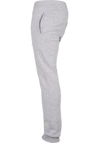 Grå sweatpants med mjukt stickat material, smal passform, sidofickor och elastiska muddar vid anklarna. Designade för komfort och lätt att bära.