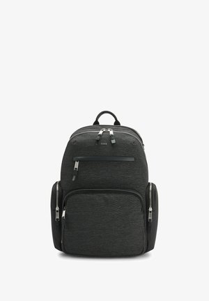 Zwarte stoffen rugzak met zilveren hardware, meerdere met een rits afgesloten vakken en een gestructureerde afwerking. Voorzien van gevoerde schouderbanden en een handvat aan de bovenkant.