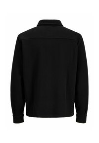 Czarna koszula z długim rękawem, kołnierzykiem, teksturowanej tkaniny oraz mankietami zapinanymi na guziki. Posiada karczek na plecach, bez widocznych logo czy wzorów.