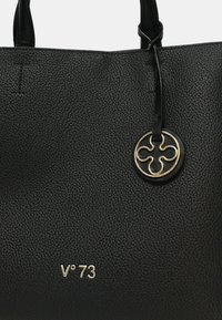 Zwarte gestructureerde leren tote bag met een ronde gouden accenttag en het verhoogde "V°73" logo in de onderste hoek.