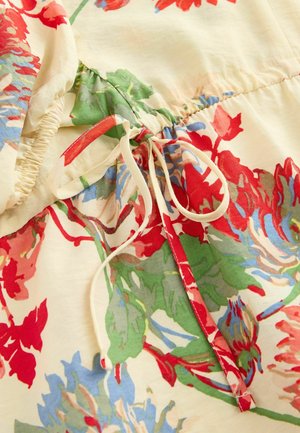 Abito floreale in tessuto crema, con una combinazione di fiori rossi, blu e verdi. Dettagli elastici e una coulisse in vita.