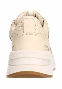 Beige sneaker met een gestructureerd, reptielachtig patroon op de hiel, platte crèmekleurige zool en subtiele gele accentstrepen aan de achterkant.